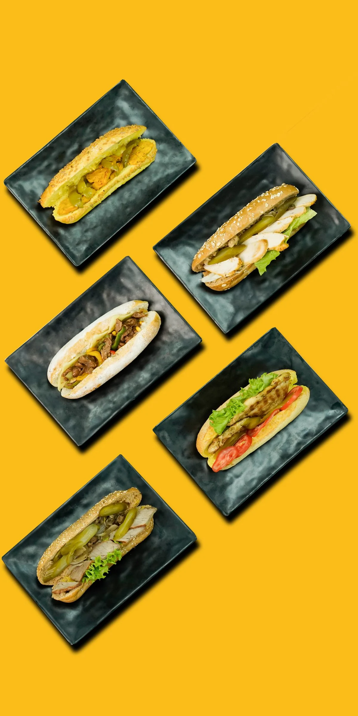 A selection of freshly prepared sandwiches presented on dark serving plates